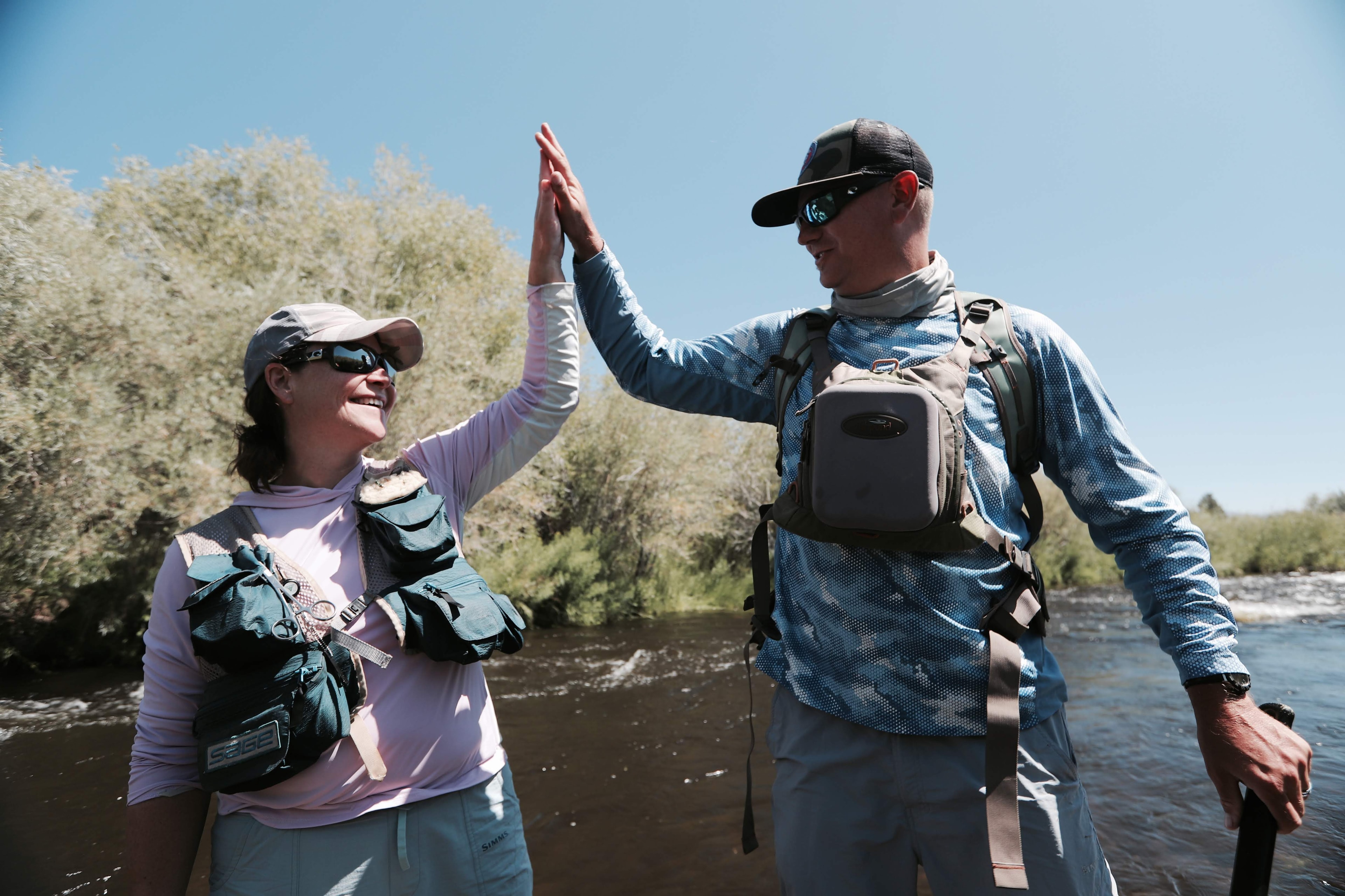 Guide and angler high-fiving on the East Walker River after landing a fish, pure celebration