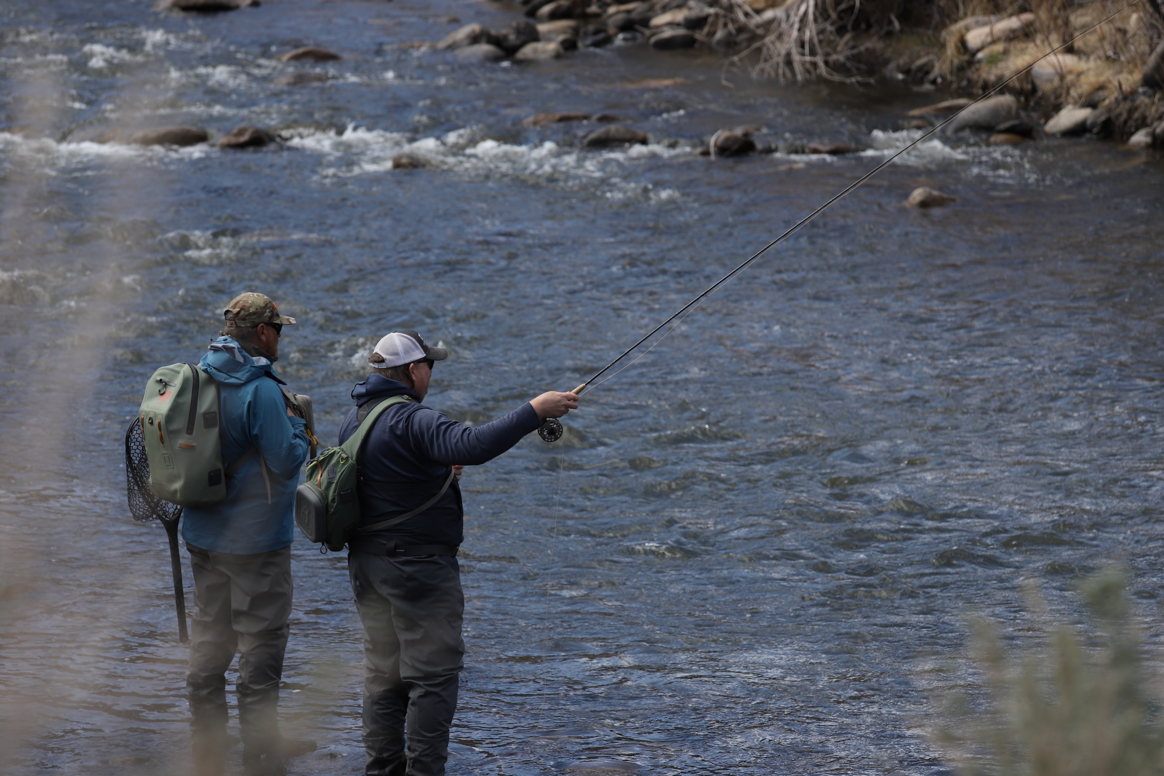 Two anglers wading the East Walker through open sagebrush meadow with mountain backdrop
